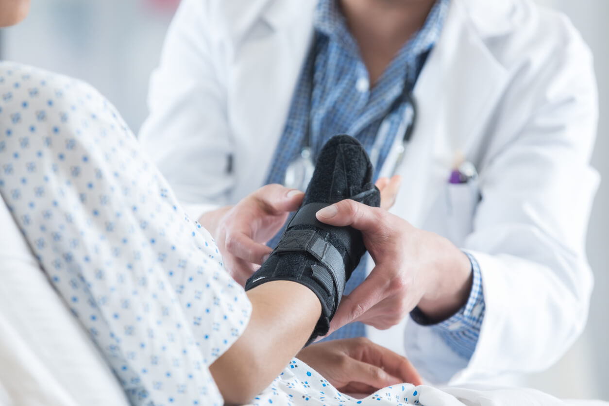 orthopedist places brace on patient's arm at orthopedic urgent care