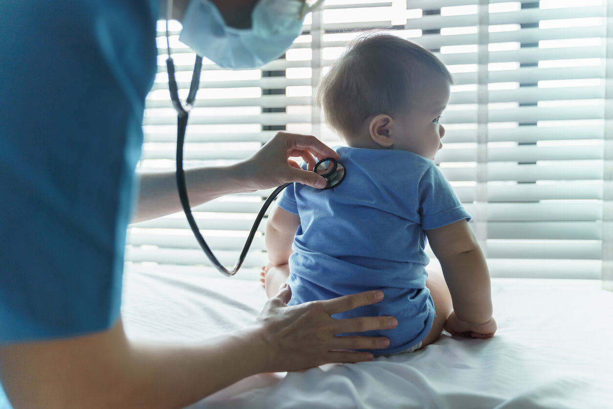 female Pediatrician doctor examining her little baby