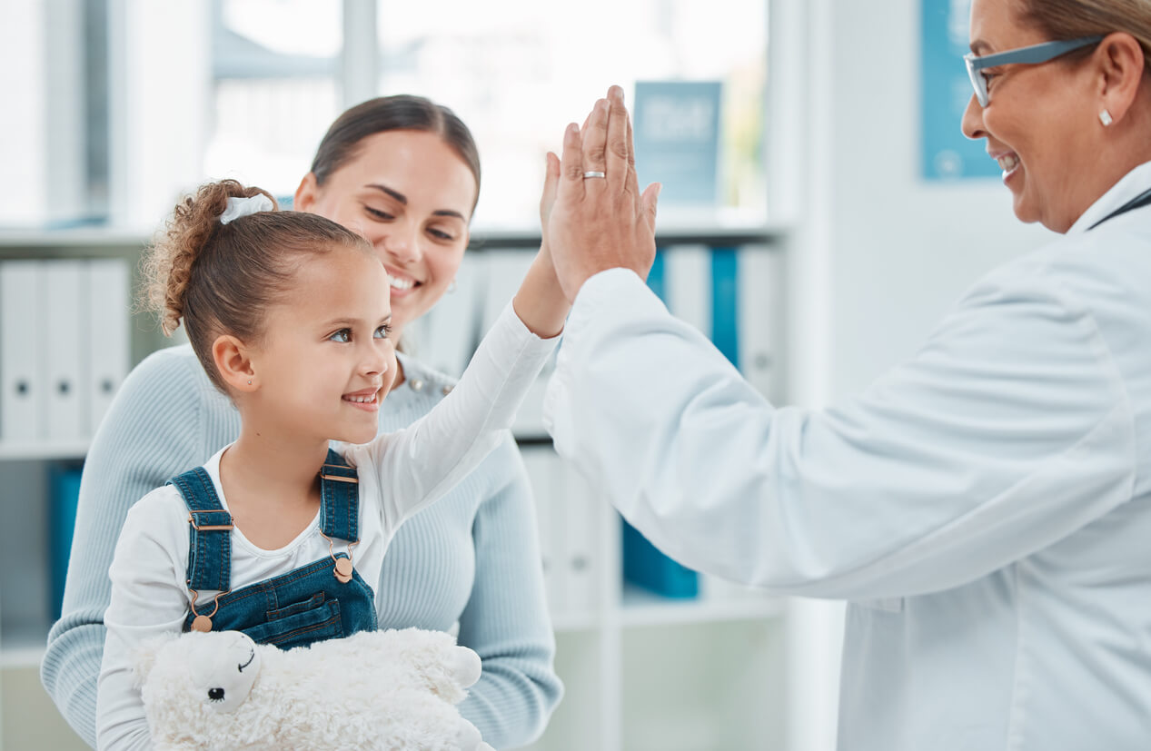 Shot of a little girl giving a pediatrician doctor a high five in a clinic