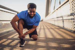 An outdoor sports trainer is experiencing pain due to a torn and sprained ankle.