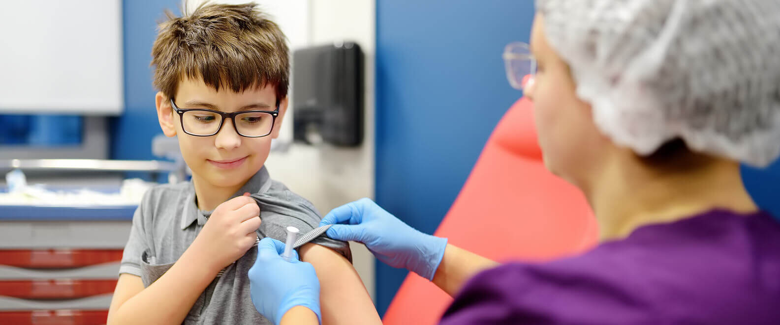 A boy is receiving a flu shot vaccine to prevent disease outbreaks.