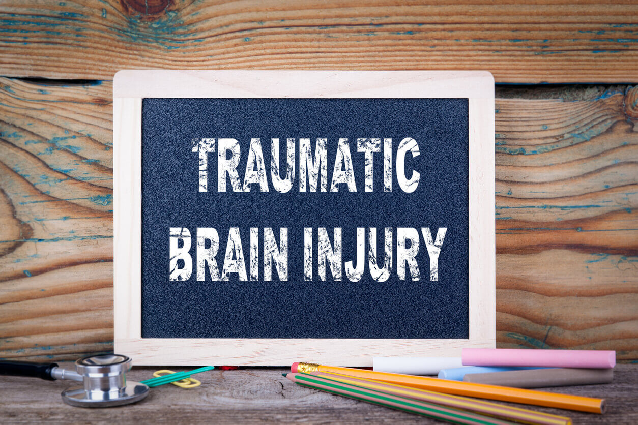 Traumatic brain injury written with chalk on a wooden blackboard.