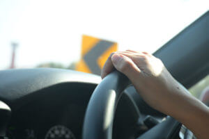 Female driver hand hold steering wheel drive vehicle car
